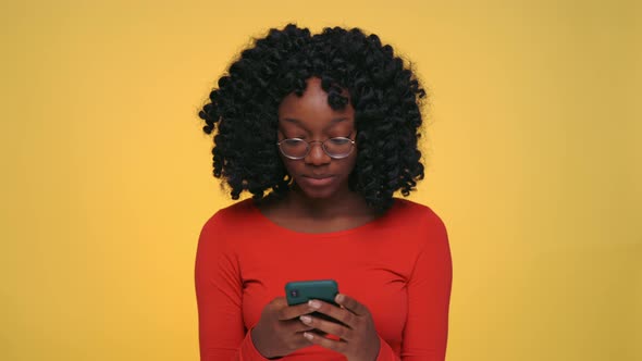 Happy African Woman Typing Messages on Smartphone