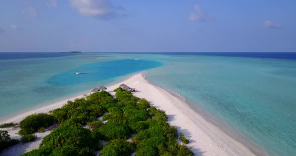 Wide angle aerial tourism shot of a white paradise beach and blue sea background in vibrant 4K