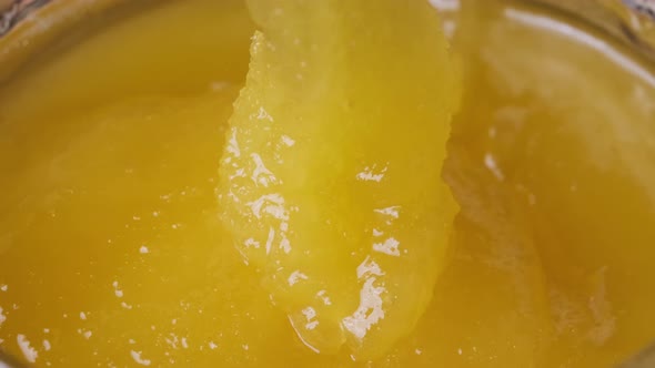 Crystalline Honey in a Jar, Macro, The Spoon is Dipped in thick Honey