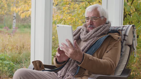 Senior Man Having Video Talk Using Tablet on Terrace