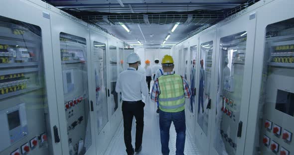 Electrical Workers Walking in the Control Room