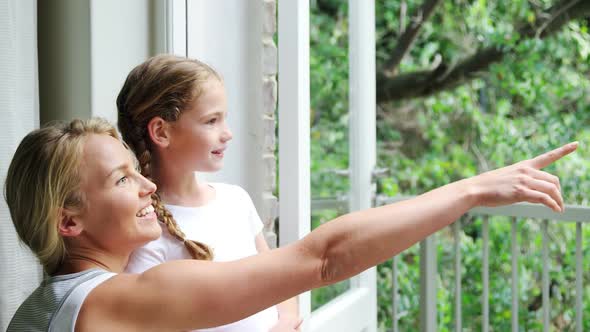 Mother and daughter standing together in balcony 4k