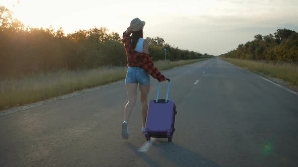 Traveler Woman with Suitcase on Road To Travel. Concept of Travel.