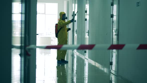 Inspector in a Splash Suit Is Sanitizing a Hallway. Coronavirus Pandemic, Virus Prevention, COVID-19