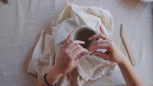 Potter Hands Modeling a Bowl From White Clay