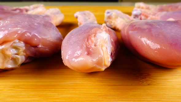 Fresh chicken legs are laid out on a cutting board.