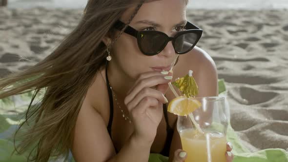 Closeup Shot of Happy Woman Drinking Cocktail on Sandy Beach