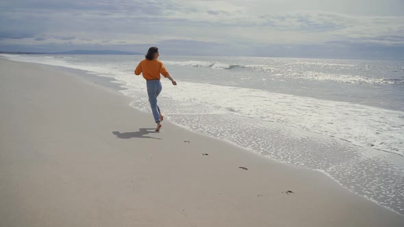 Running happy girl by the ocean