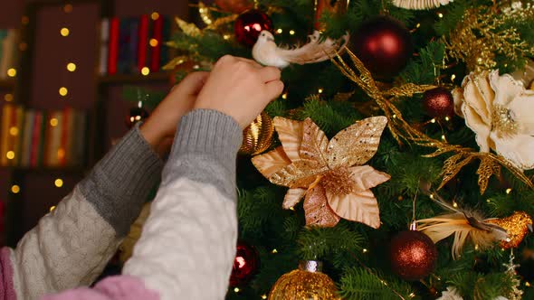 Woman Hanging Shiny Baubles on Christmas Tree