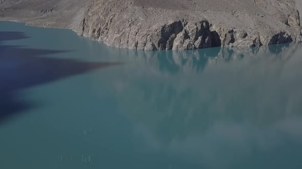Aerial Over Calm Turquoise Waters Of Attabad lake In Hunza Valley. Slow Pan Right