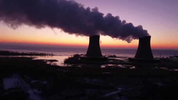 Dolly Right Aerial Drone Shot of Nuclear Power Plant Cooling Towers at Sunrise Sunset with Steam and