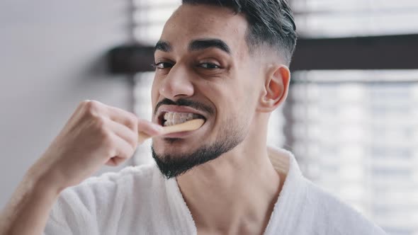 View of Reflection in Mirror Close Up Man Male Face Arab Millennial Indian Guy Looking at Camera