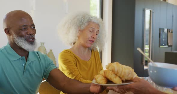 Happy senior diverse people having breakfast at retirement home