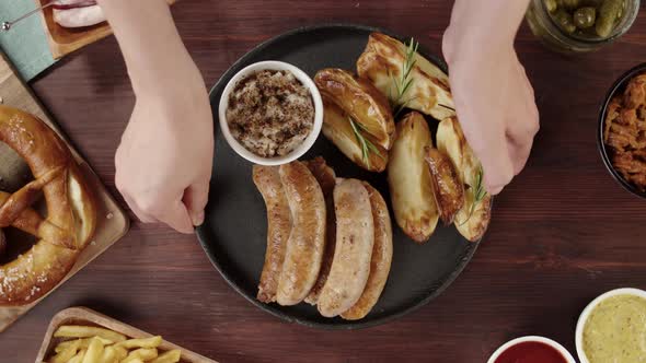 Putting Plate with Smoked Sasuages and Fried Potatoes Top View Pickled Cucumbers Bratwursts and