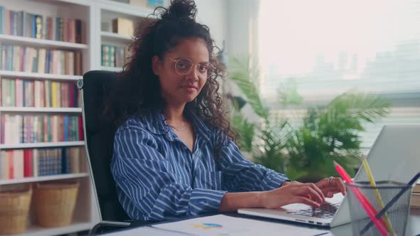 Young Indian Woman Finishes Typing on Laptop is Distracted and Looks at Camera