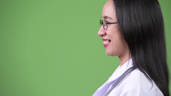 Profile View of Young Beautiful Asian Woman Doctor Smiling