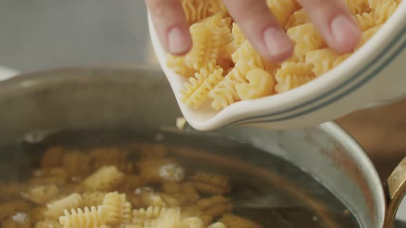 Faceless female preparing pasta in kitchen