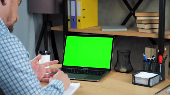 Green screen laptop: Businessman writes to-do list tells employee video call