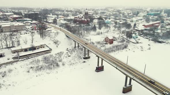 Calm Winter Landscape with Frozen River and Road Bridge Aerial View