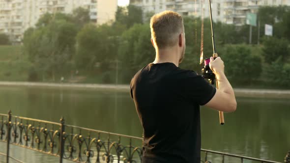 a Fisherman in a Black Tshirt is Fishing in a City Pond