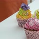 Four nicely decorated colorful muffins. Pastry cook puts cupcake on the table.  - VideoHive Item for Sale