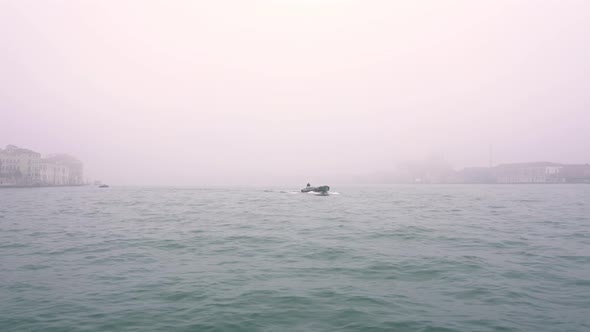 Small Motorboat Sails on Venetian Lagoon Water in Mist