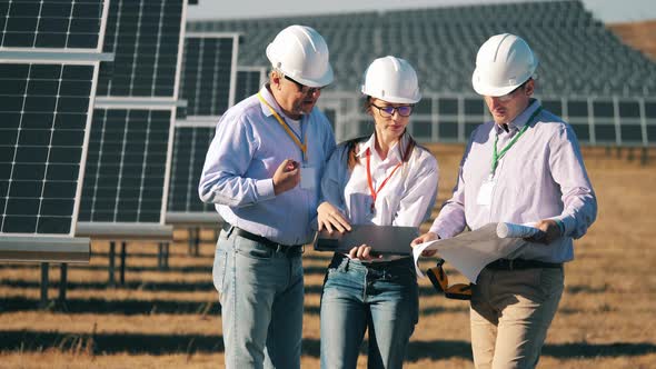 Team of Energy Engineers Monitoring a Photovoltaic Power Station, Solar Energy Concept