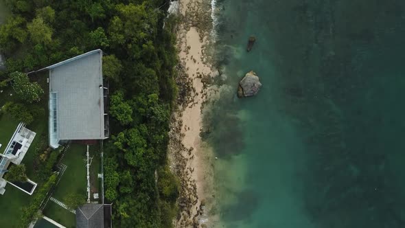 Beautiful Bingin beach with exotic cliffs houses and hotel located in Bali, Indonesia. This drone fo