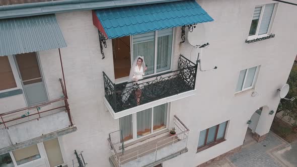 Bride in Night Gown Stand on Balcony of Her House. Wedding Morning. Aerial View