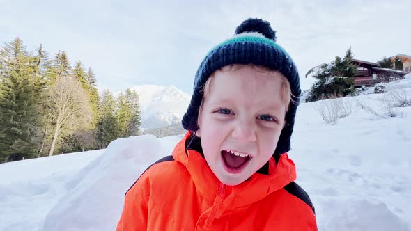 Happy Boy Play in Snow at Winter Mountains Vacation