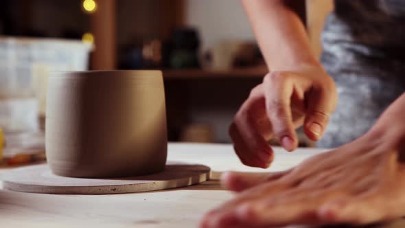 Pottery in the Studio  Young Woman Cuts Off a Small Longer Piece of Clay