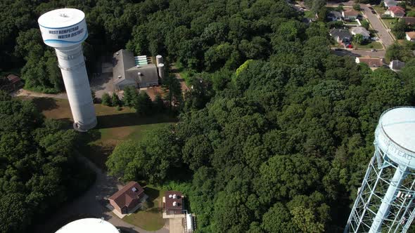 An aerial view over water towers in a suburban neighborhood on Long Island, NY on a sunny day. The d