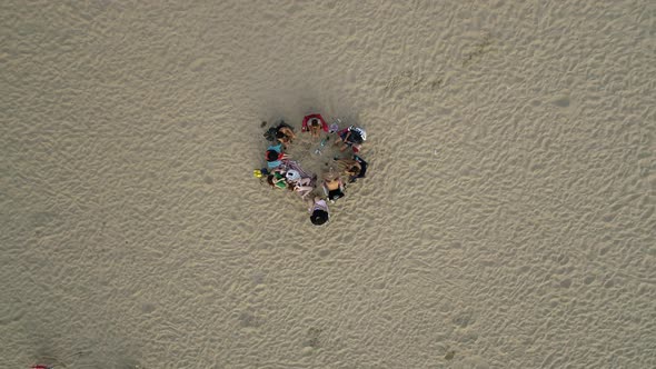 People Sitting Side By Side On The Beach