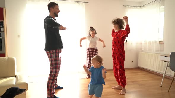 A Large Family with Three Children Doing Morning Exercises in Pajamas