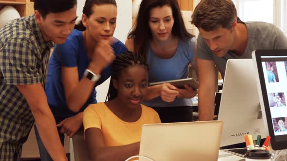 Business executives discussing over laptop