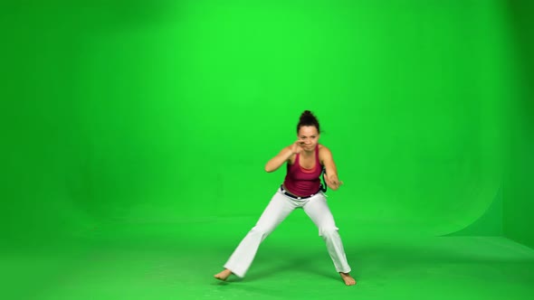 Brunette Female Practicing Capoeira on Green Screen.