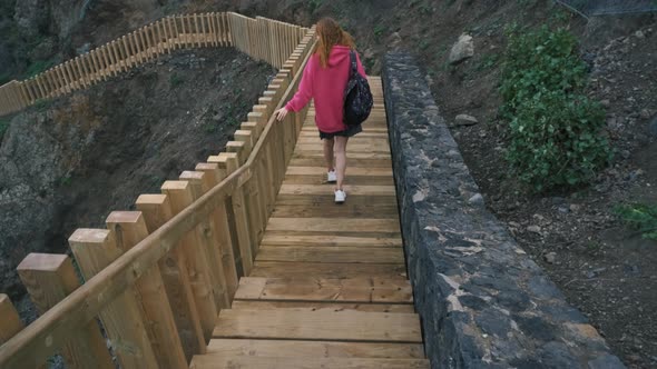 Young Woman Tourist Goes Down the Long Stairs to the Famous Volcanic Black Sand Beach Benijo in the