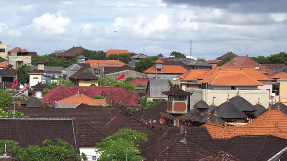 Static Shot of the Rooftops in Bali, Indonesia with a Plane Flying in The Distance