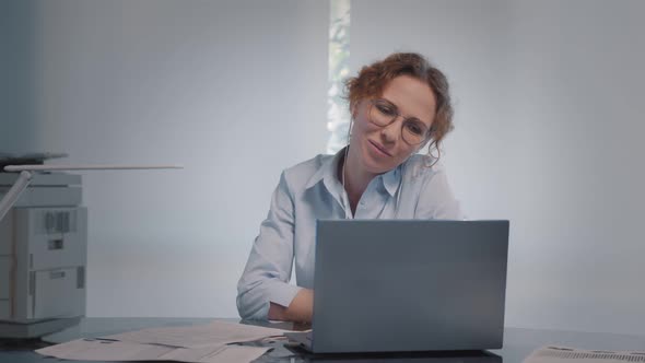 Young Woman Having Video Call Via Laptop and Earphones in Office