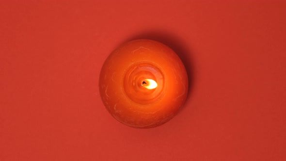 Red Round Burning Candle Isolated on Red Background