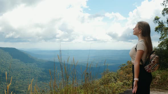 Inspired Travel Woman with Backpack Stands on Top Mountain Open Arms Breathes