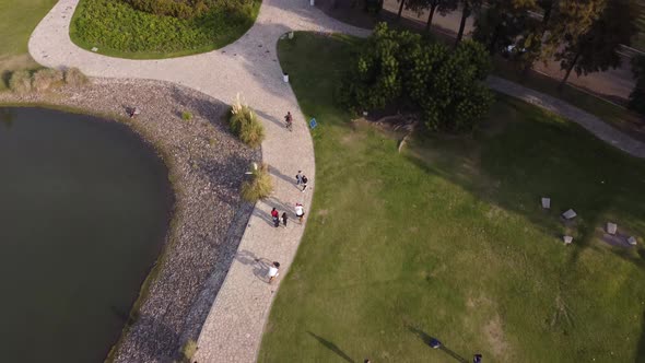 People cycling by lake through Palermo Park