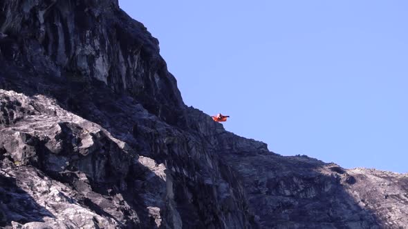 Man diving down in a wing suit in the mountains of Norway, Slow motion.