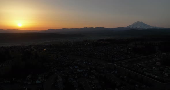 Panning aerial of the sunrise and a mountain on the horizon.