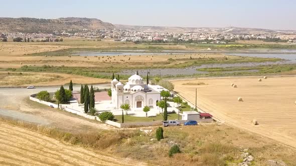 Drone Flying Towards Beautiful White Church With Stunning Lake  Background, Larnaca City, Cyprus