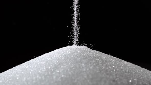 Pile of sugar on black background, Slow Motion alt