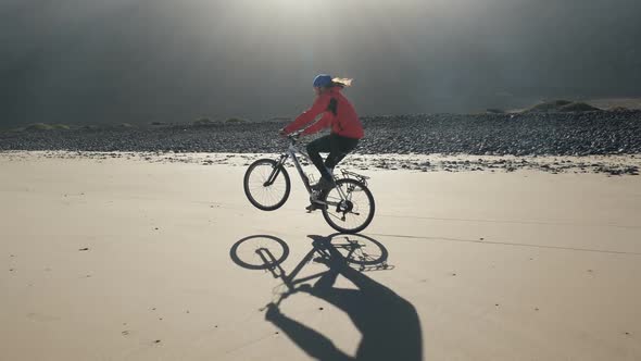 Young Man Rides a Bicycle on a Sand Beach on Canary Islands