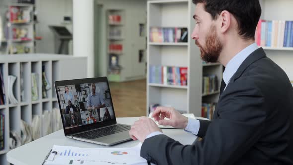 Successful Man Using a Laptop Conducts Virtual Meeting with Business Partners on a Video Call