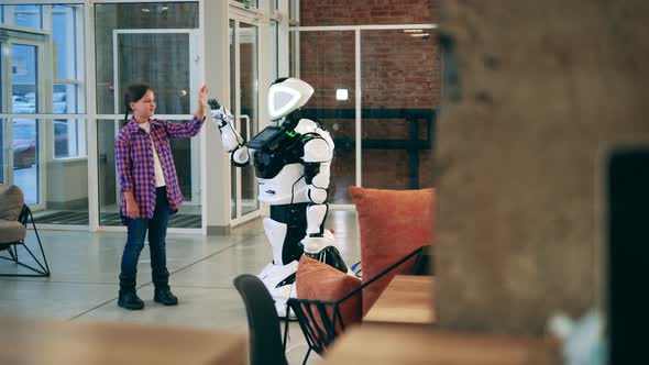 Humanlike Cyborg and a Little Girl Are Touching Hands