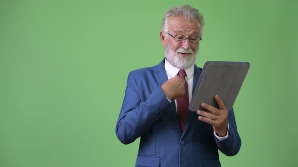 Handsome Senior Bearded Businessman Against Green Background